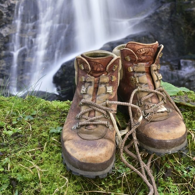 Wild Isles of Mull & Iona, hiking boots and mossy wall with waterfall behind, Carsaig.